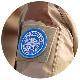 Arm med jakkemerke til FN-soldat. Foto.